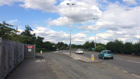 Cycle route crossing entrance to industrial site.