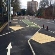 A segregated cycle lane on Wilmslow Road crossing the mouth of a side road