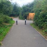 Two bollards preventing motor vehicle access to a shared use lane.