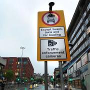 Signs notifying drivers of enforcement cameras for a bus lane.
