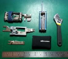 A selection of bicycle multitools, along with an adjustable spanner and a ruler for scale.